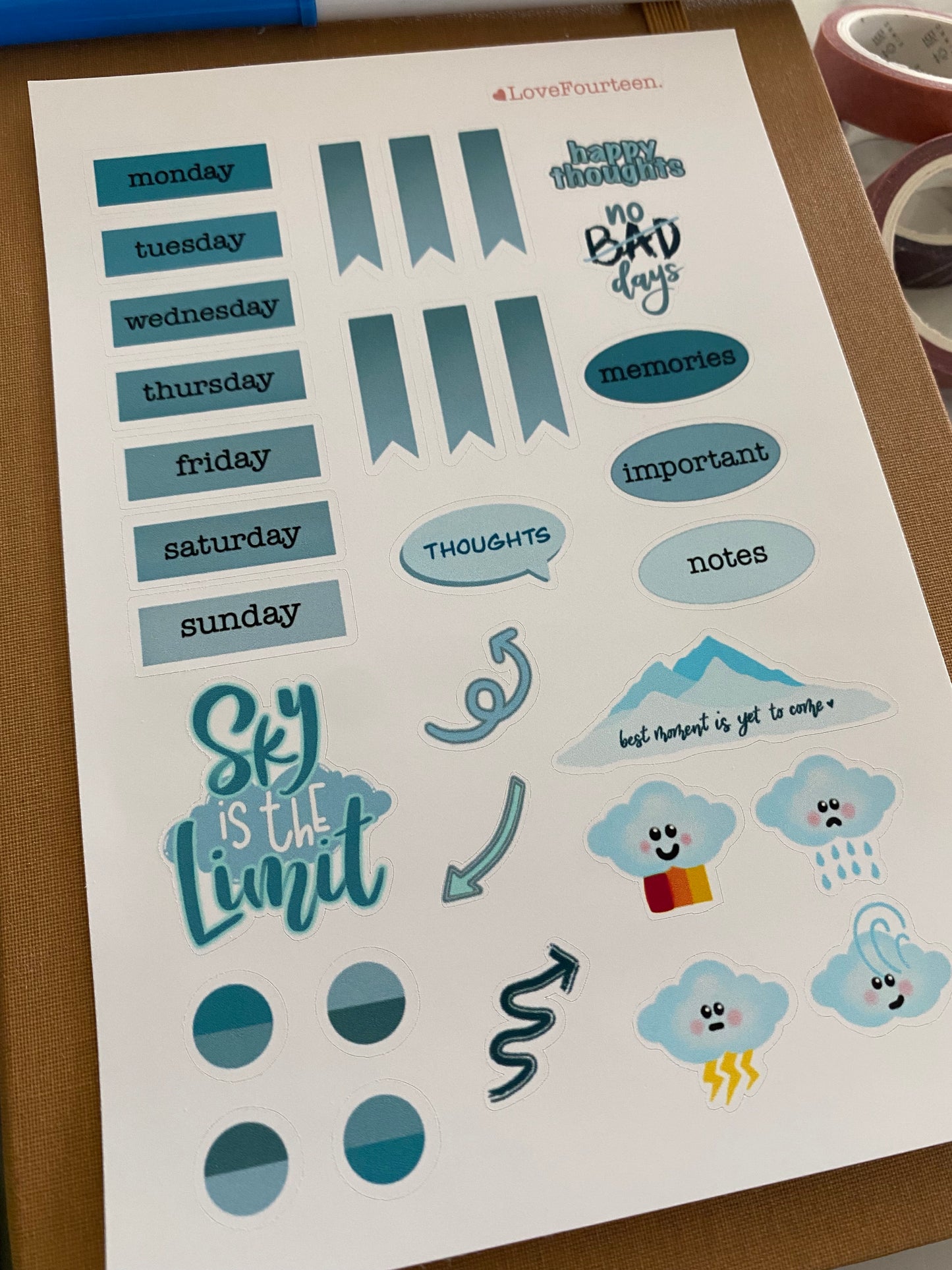 Blue color theme journal sticker sheet on top of a planner.