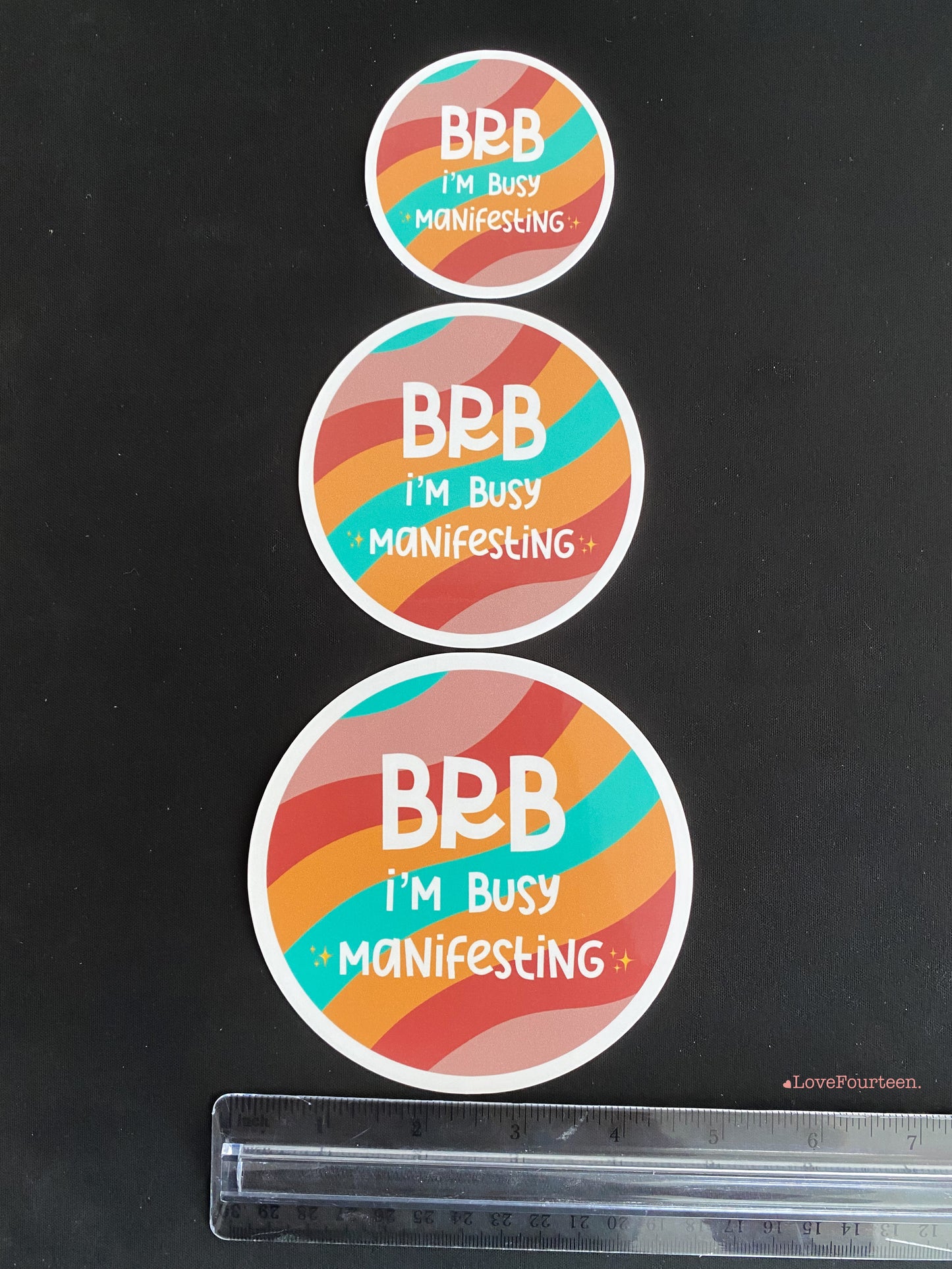 Showing the size variant for the BRB I'm busy manifesting waterproof die cut sticker with a ruler for reference
