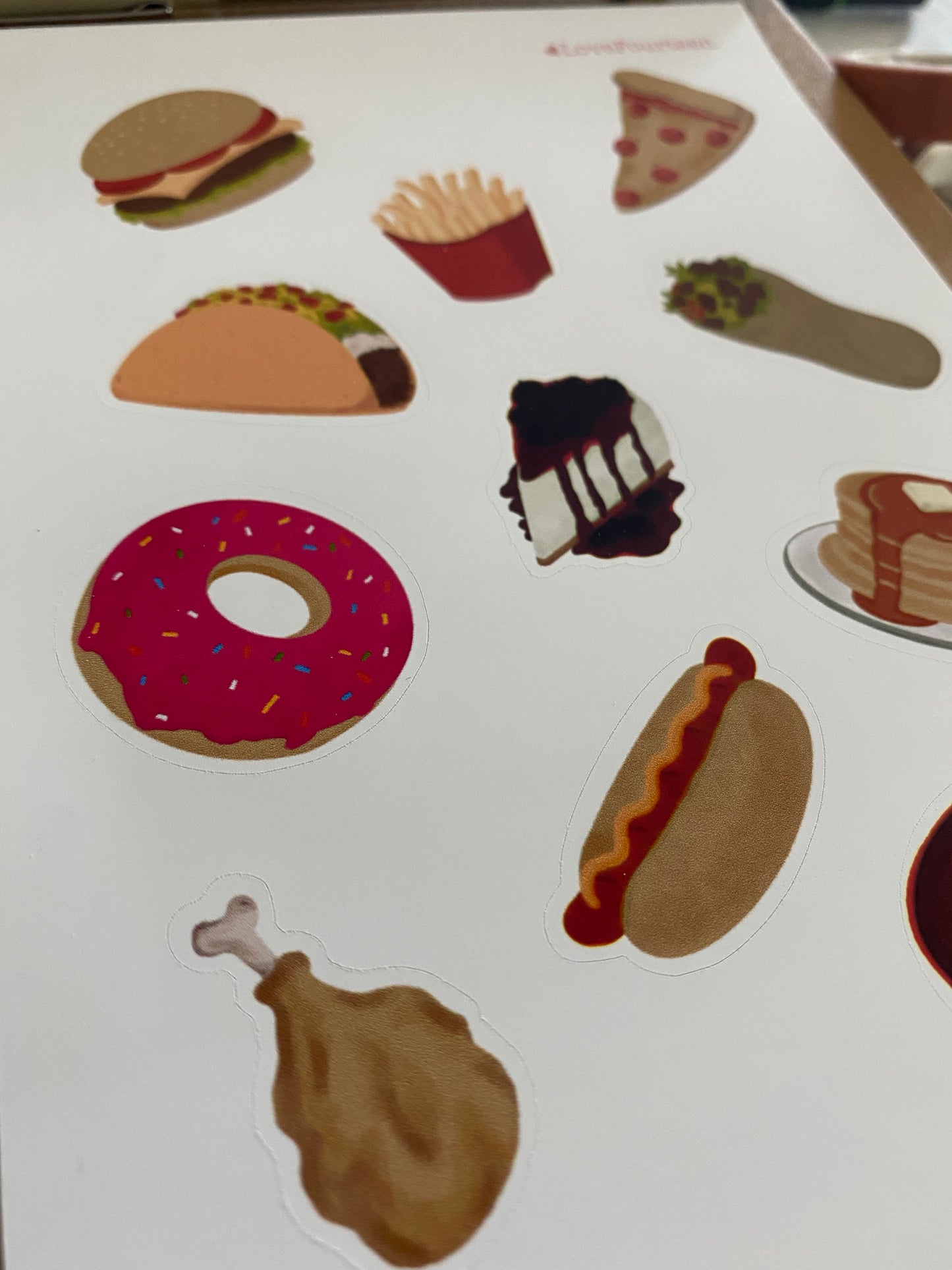 A closer look of journal sticker of comfort food like burger, fries, pizza, tacos, cheesecake, burrito, donut, pancakes, hotdog, chicken, and ramen