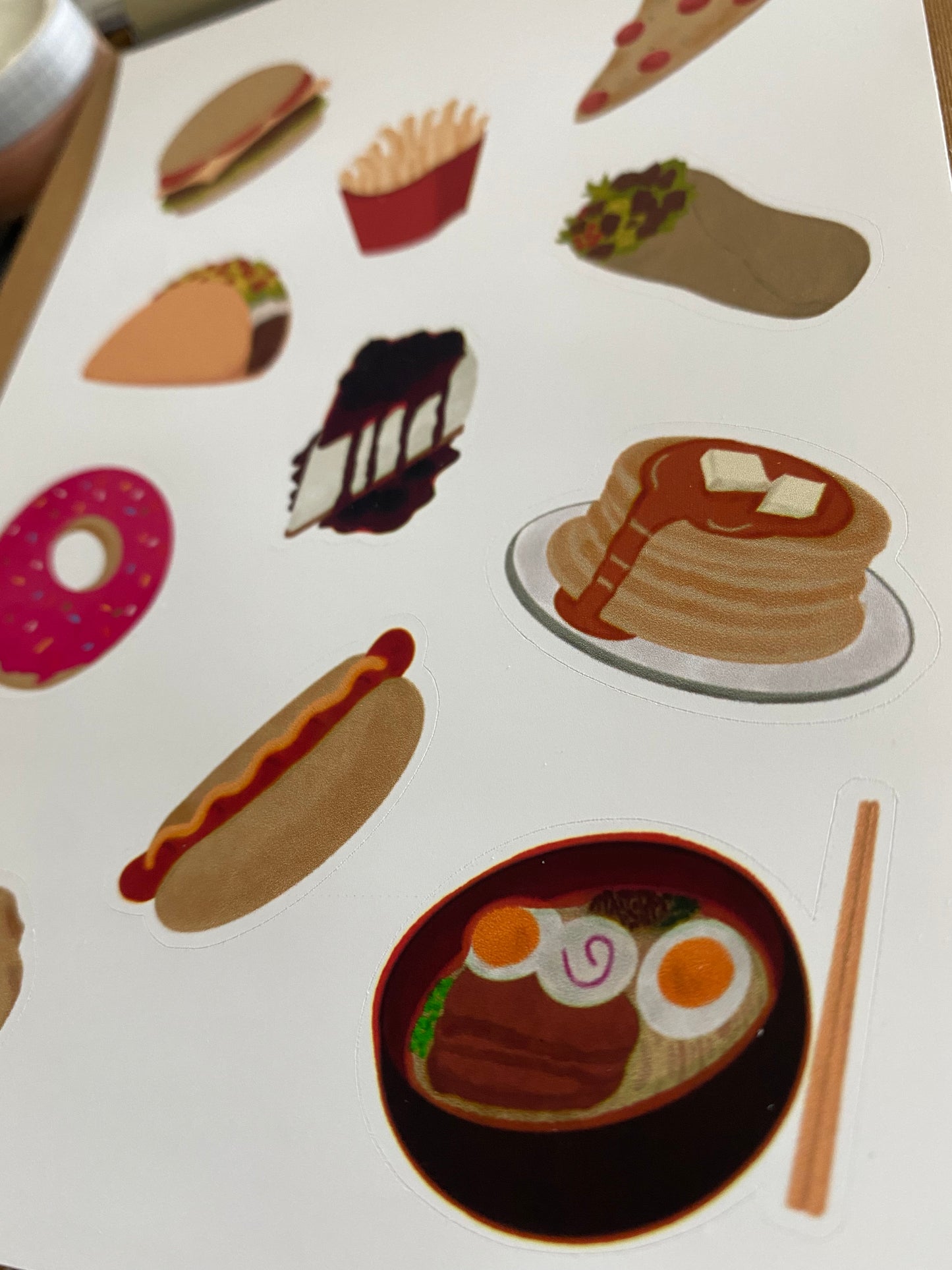 A closer look of comfort food journal sticker showing ramen, hotdog, pancakes, cheesecake, donut, burrito, tacos, fries, pizza and burger