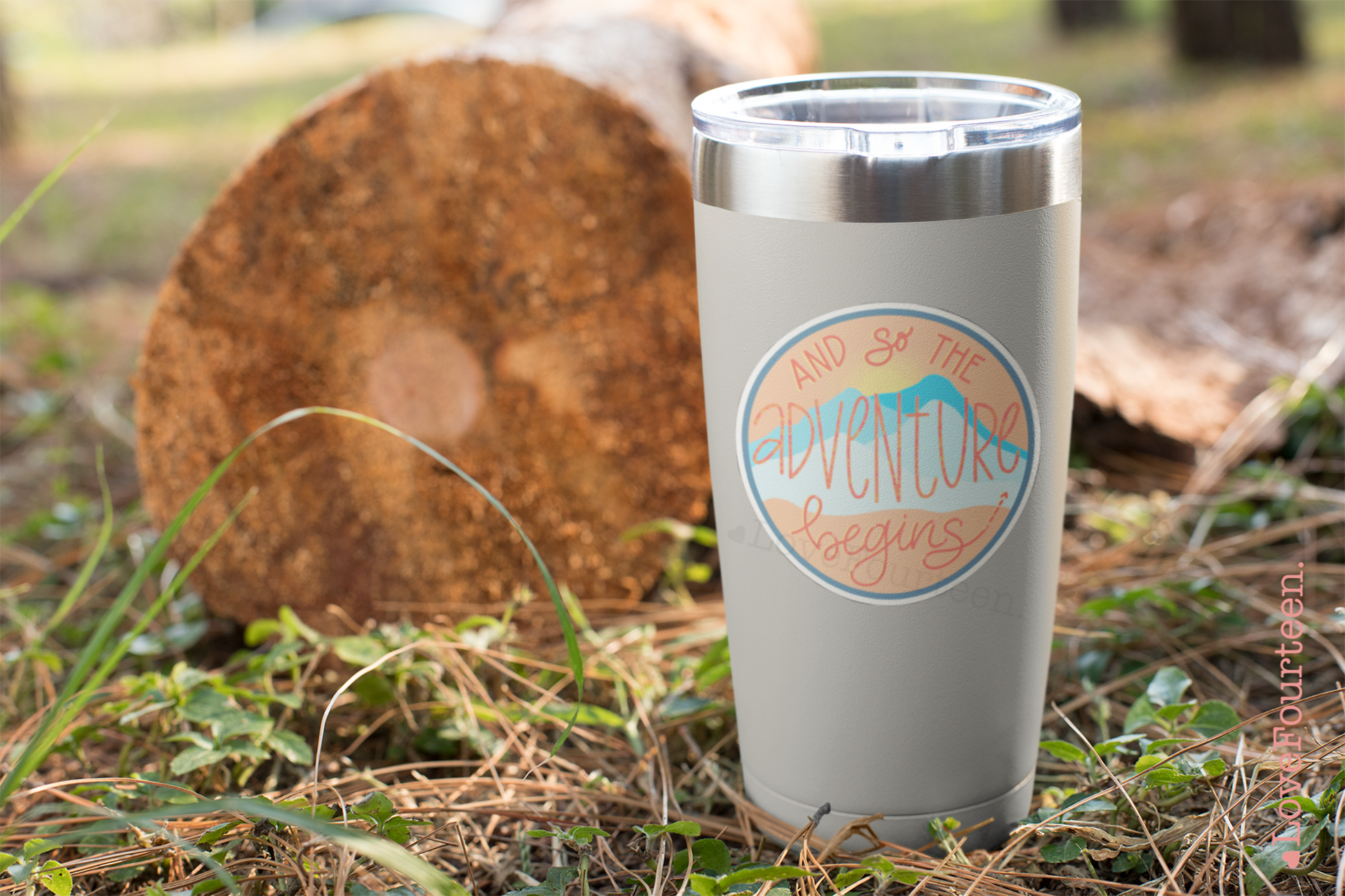 Tumbler on the ground with a waterproof die cut sticker saying "and so the adventure begins"